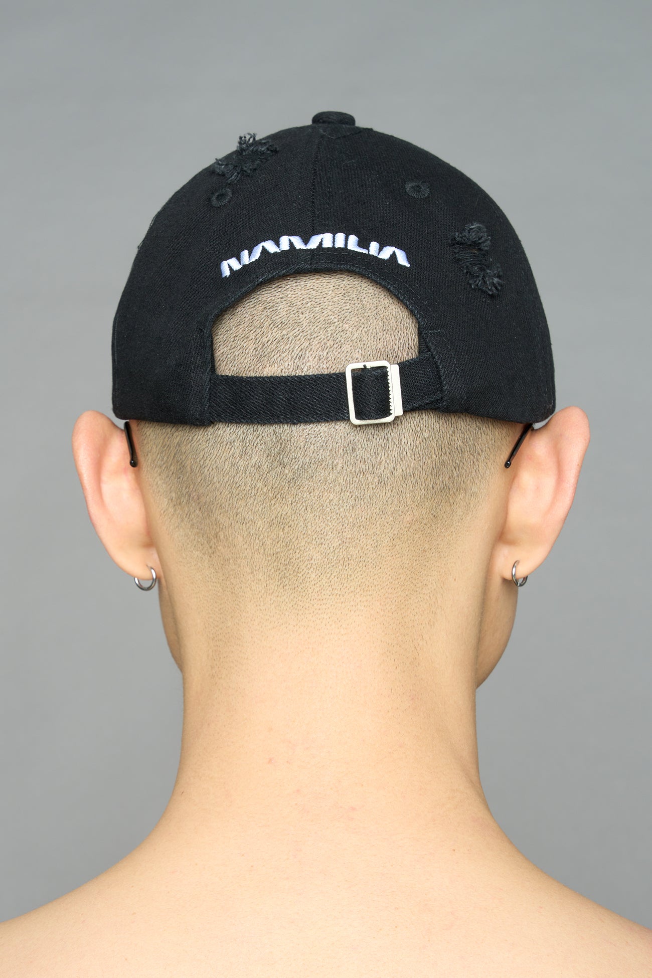 model wearing black red slogan embroidered rtrucker cap with silver ring details