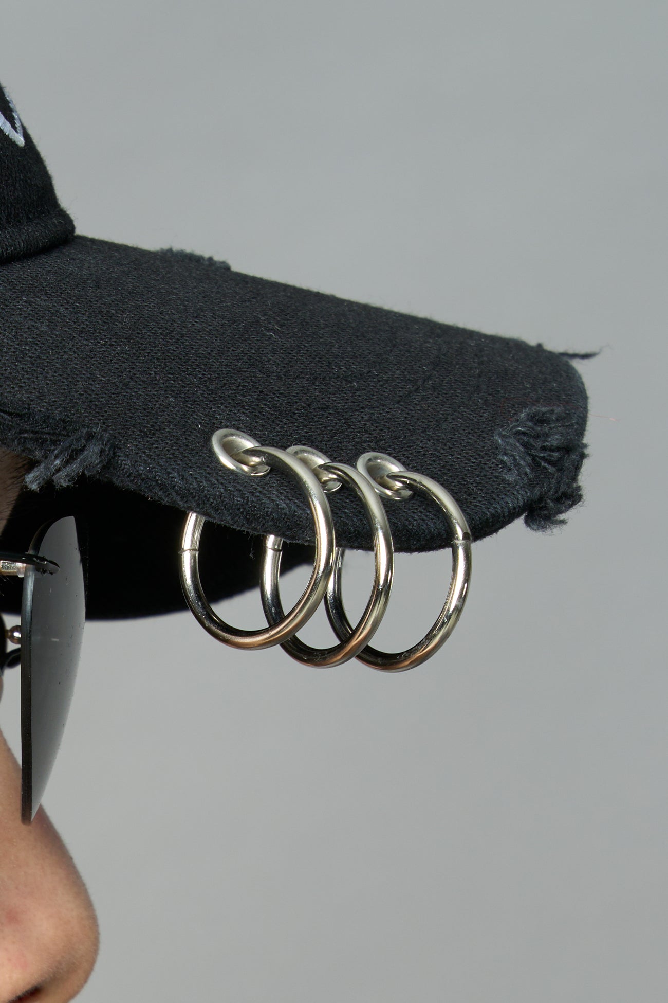 model wearing black red slogan embroidered rtrucker cap with silver ring details