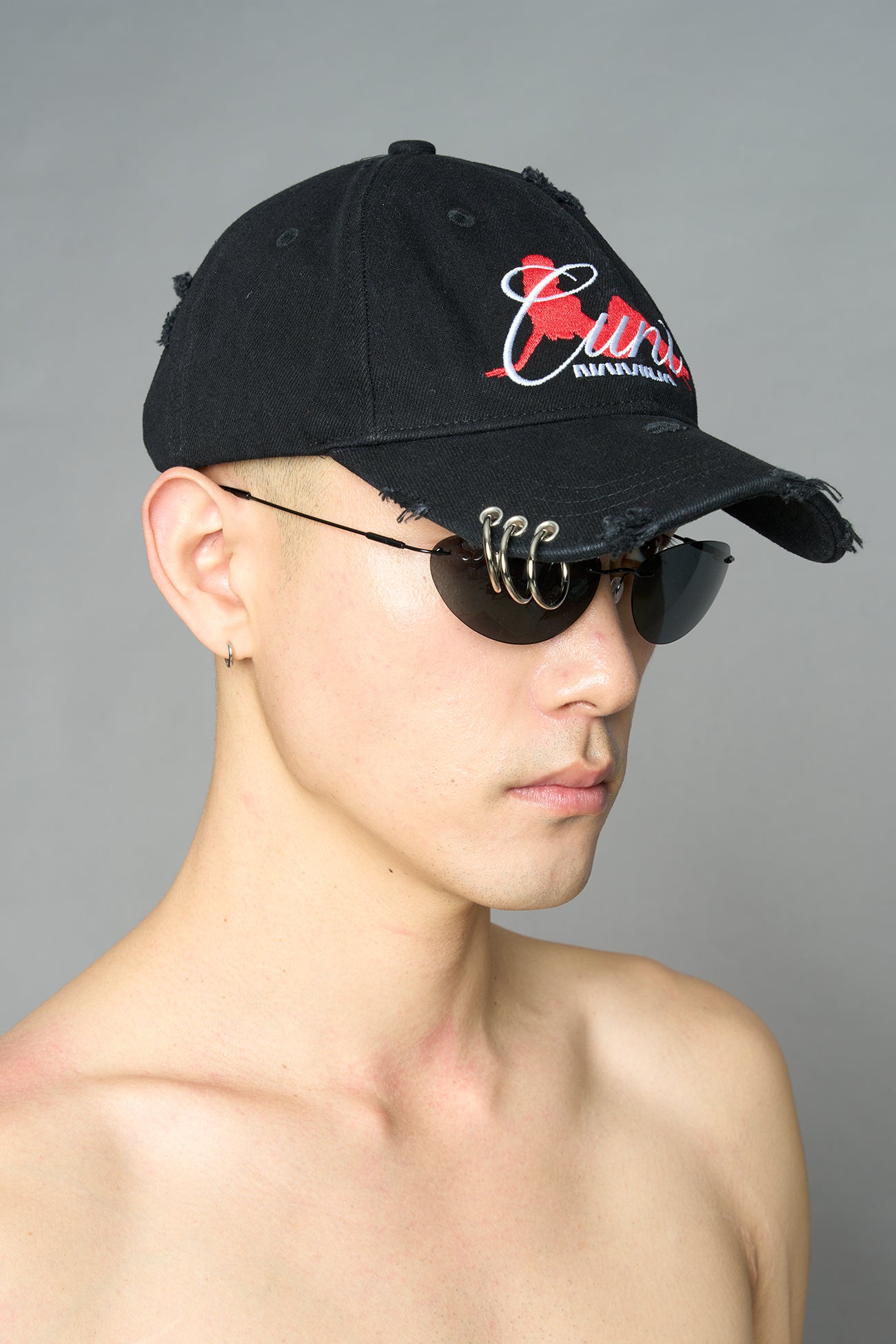 model wearing black red slogan embroidered rtrucker cap with silver ring details