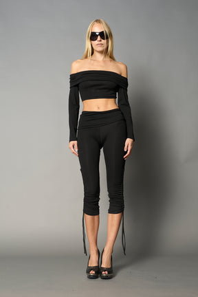 model wearing off shoulder top black with foldover detail and long sleeves