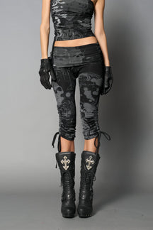 Model wearing black print capri pants with ruched sides and matching off-shoulder crop top