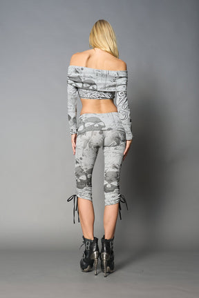 Model wearing grey print capri pants with ruched sides and matching off-shoulder crop top