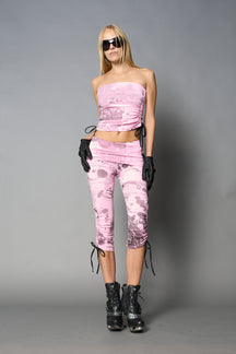 Model wearing pink print capri pants with ruched sides and matching off-shoulder crop top