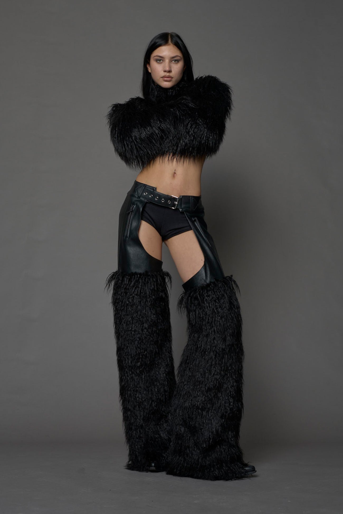 model wearing black vegan leather and faux fur chaps