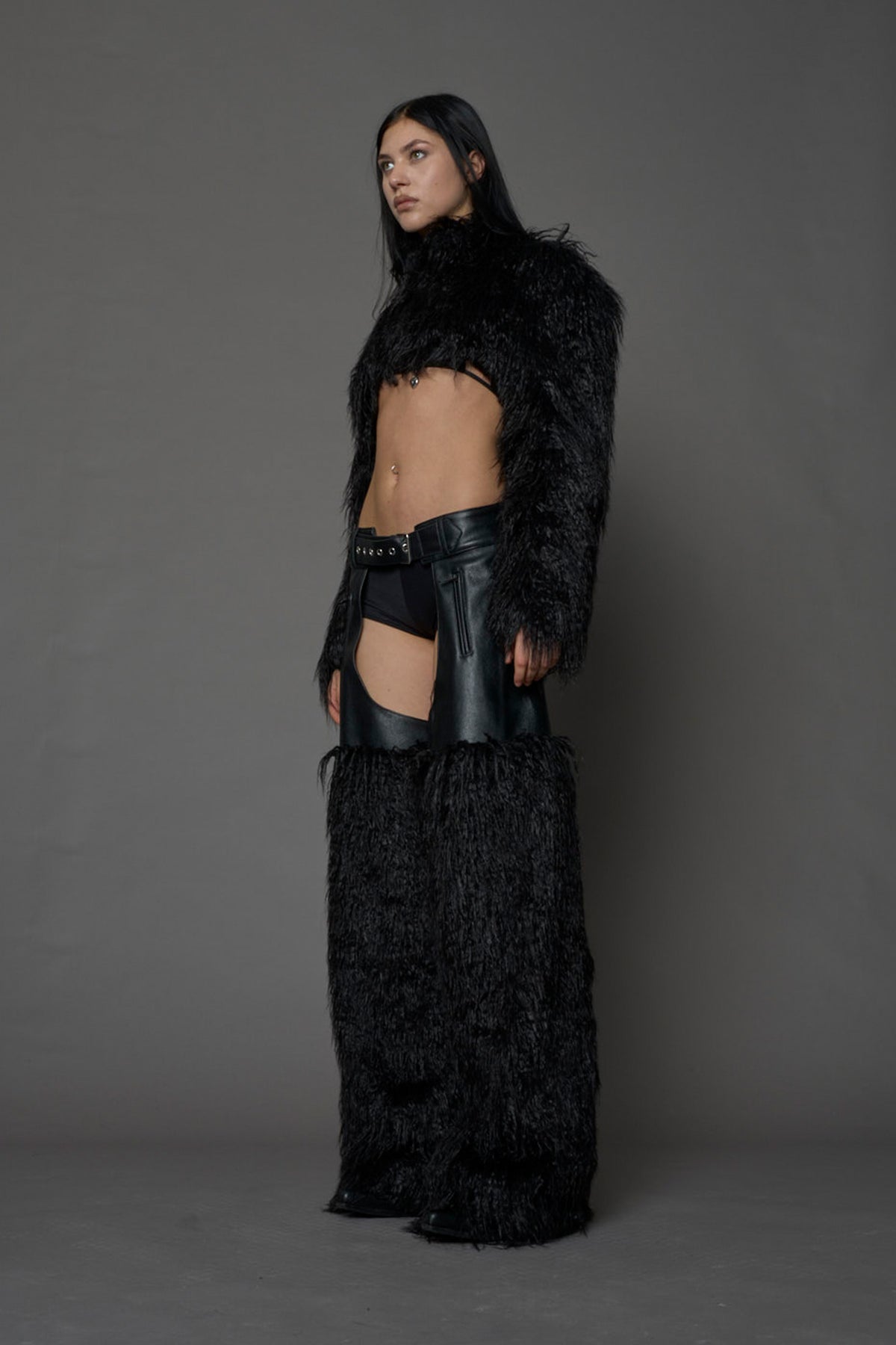 model wearing black vegan leather and faux fur chaps