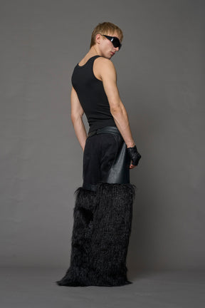 model wearing black vegan leather and faux fur chaps