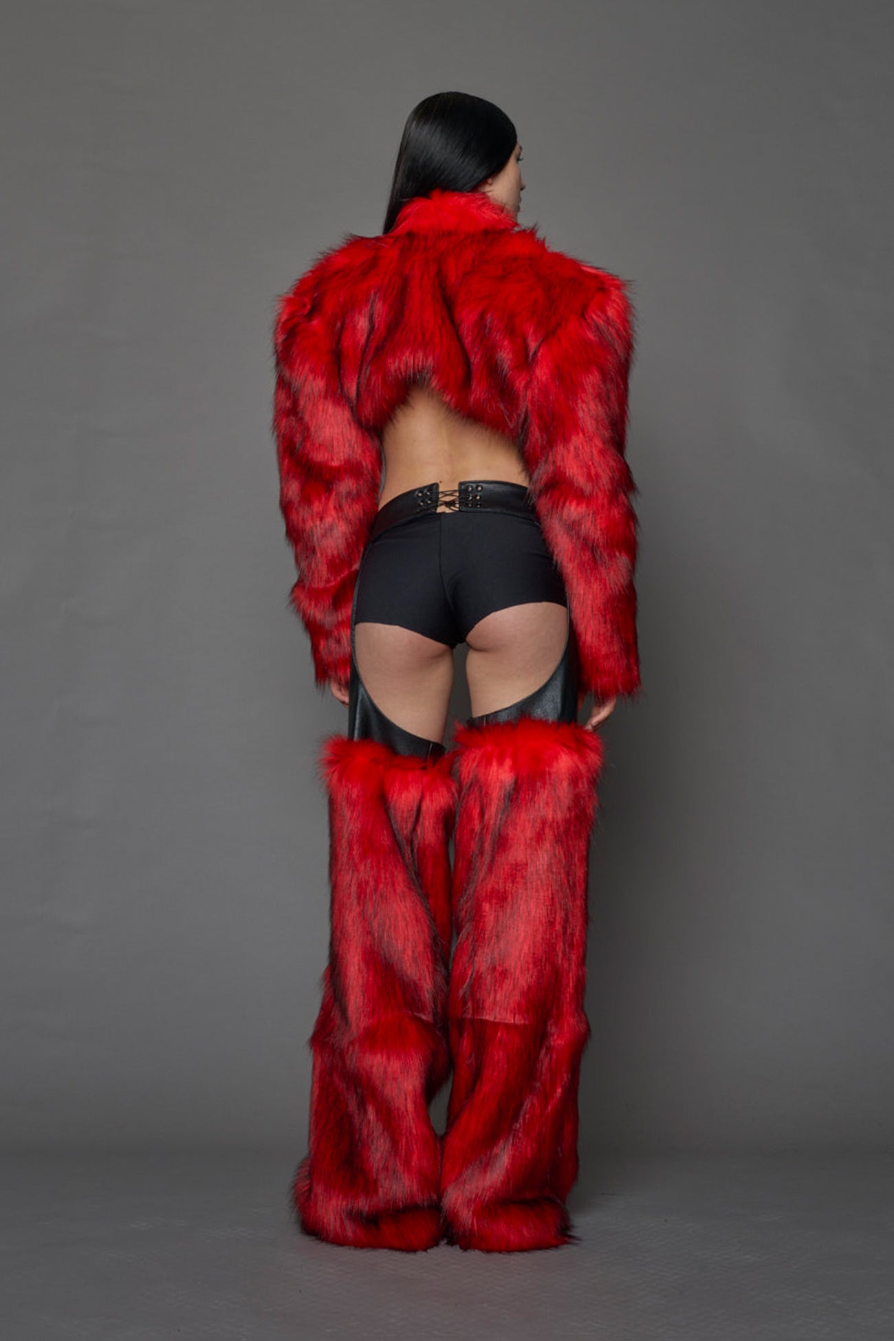 model wearing red vegan leather and faux fur chaps