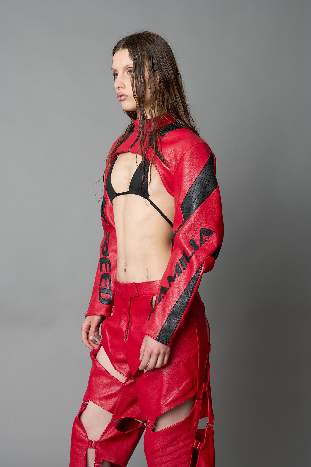 Model wearing a red vegan leather cropped jacket with a high choker collar and zipper front