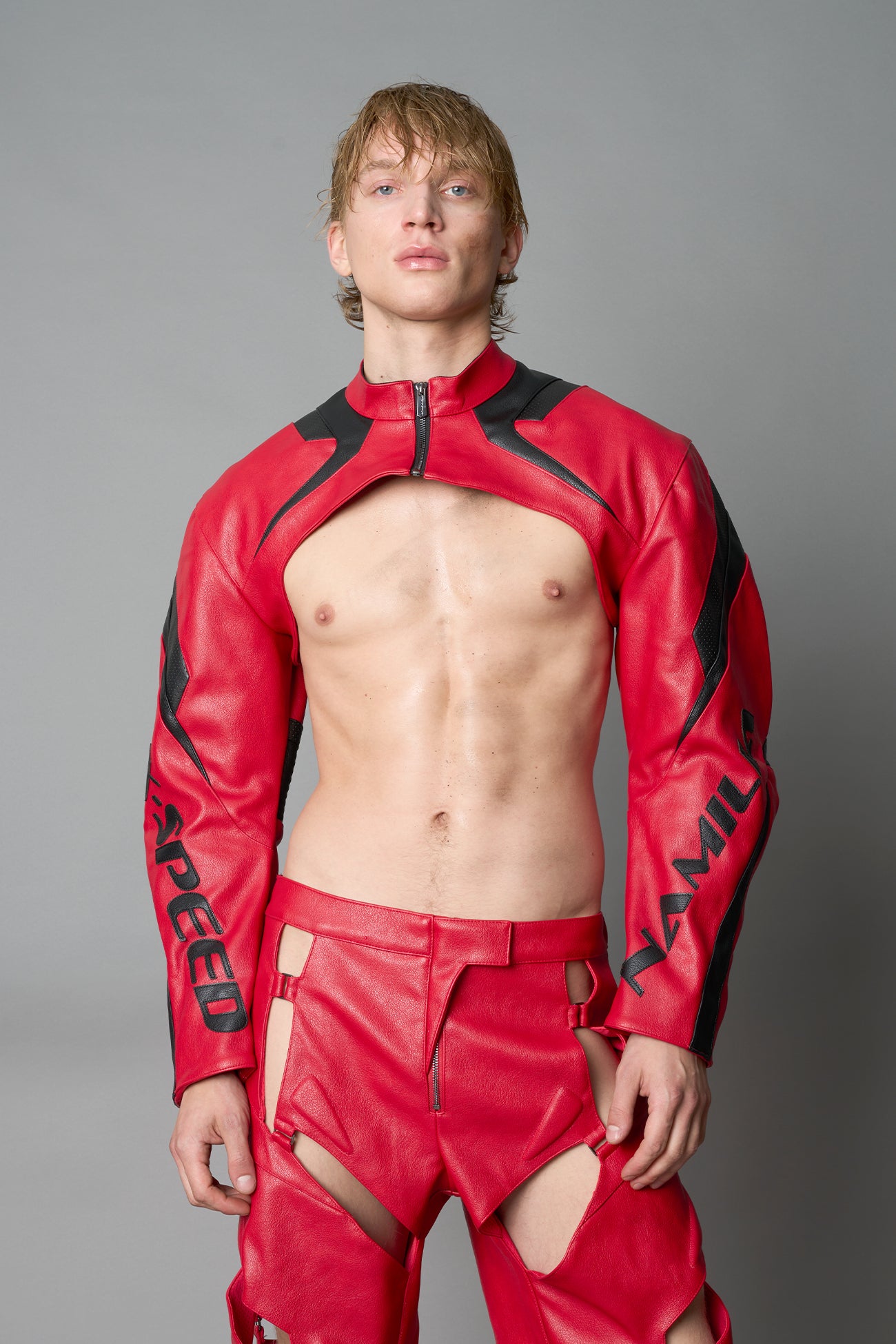 Model wearing a red vegan leather cropped jacket with a high choker collar and zipper front