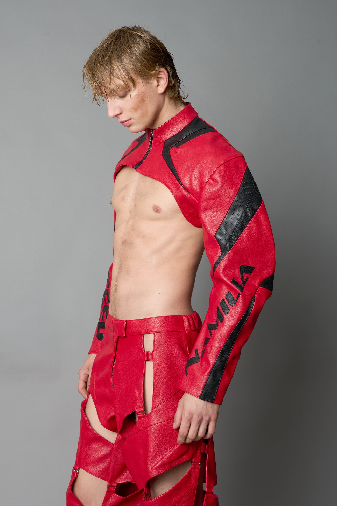 Model wearing a red vegan leather cropped jacket with a high choker collar and zipper front