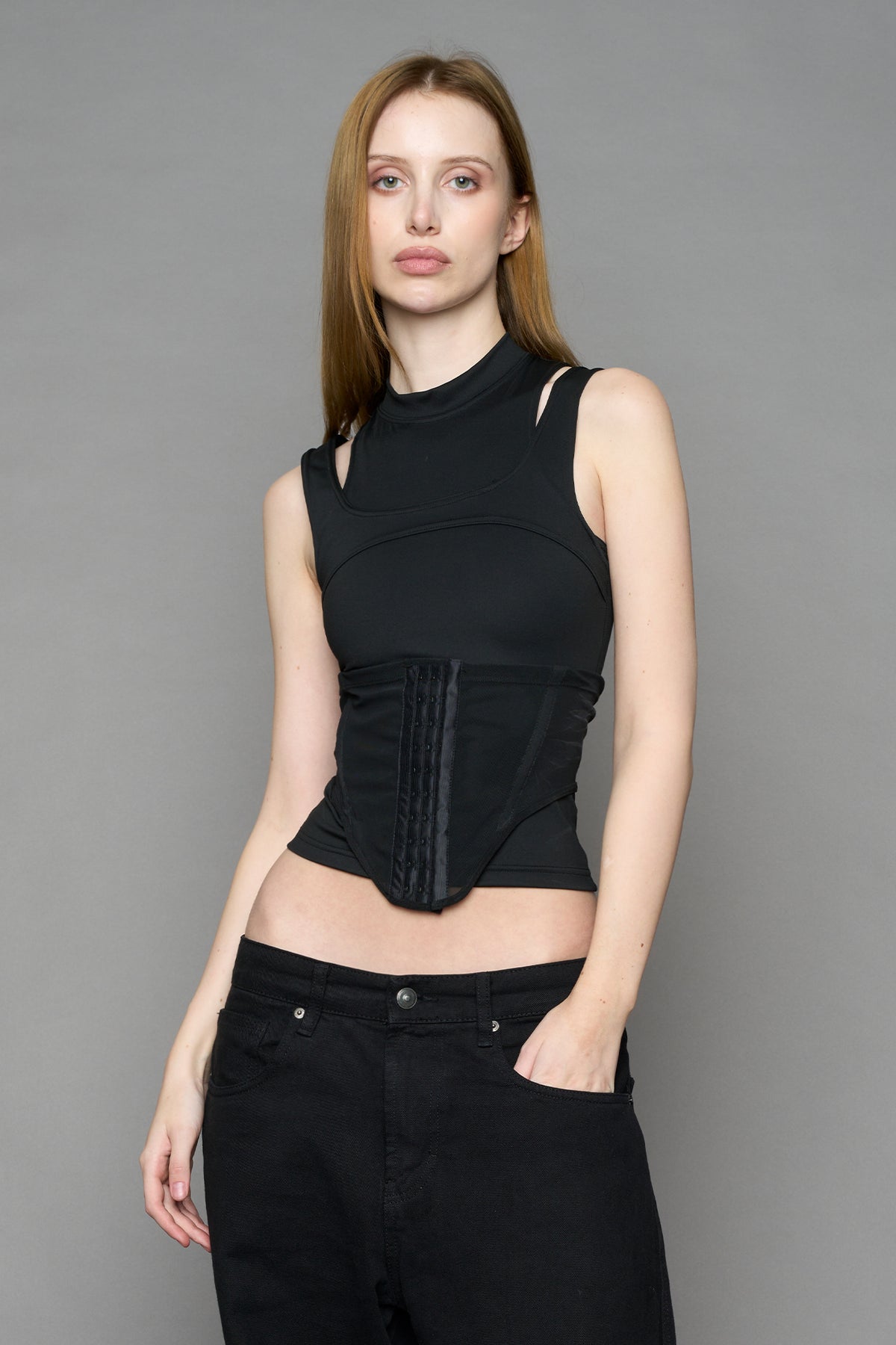 Black contour top by NAMILIA featuring a sculpted fit, corset-style waist with hook-and-eye closure, and high neckline. Statement shaping top.