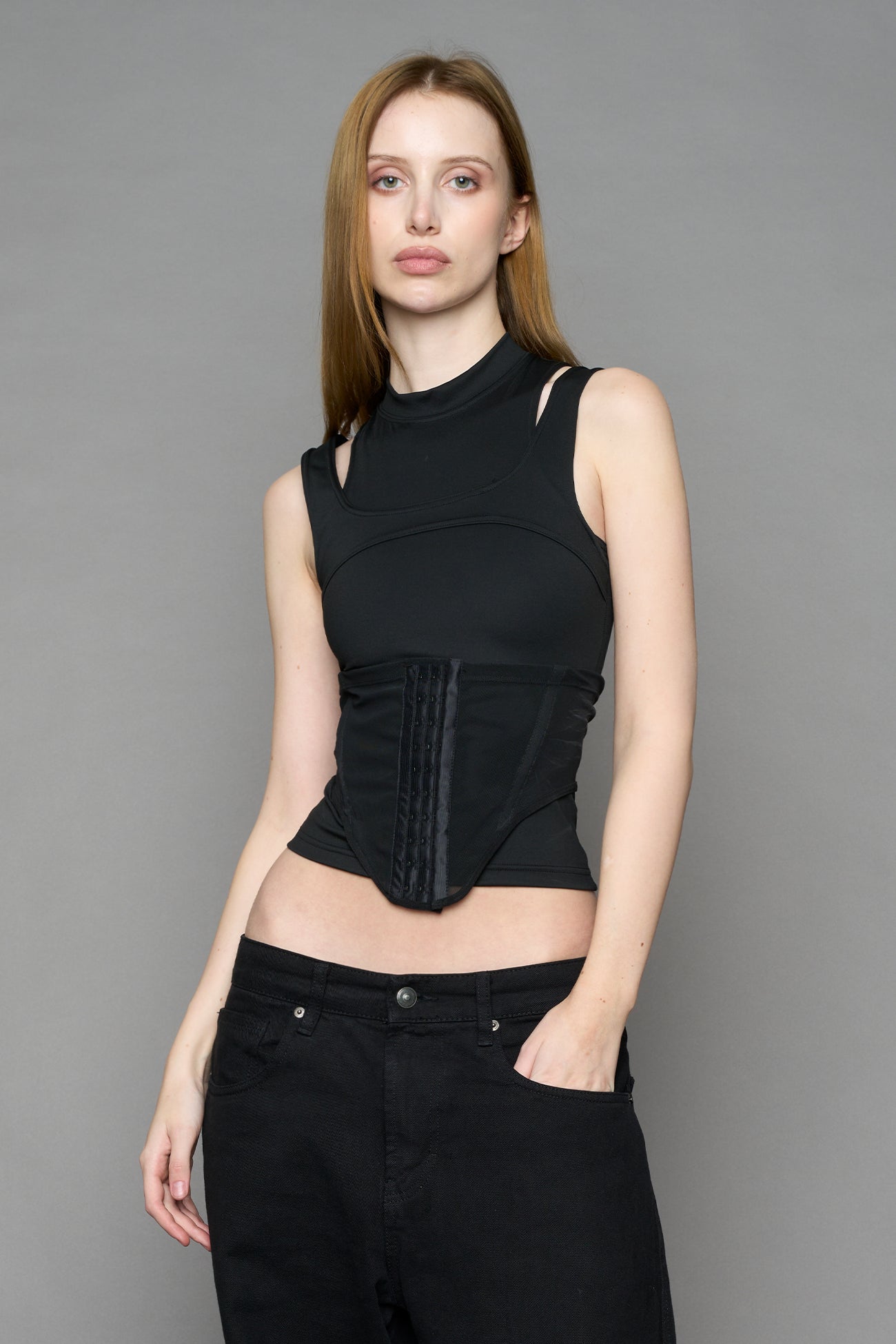 Black contour top by NAMILIA featuring a sculpted fit, corset-style waist with hook-and-eye closure, and high neckline. Statement shaping top.