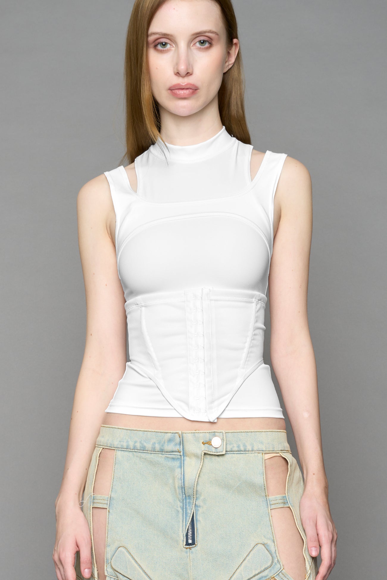 white  contour top by NAMILIA featuring a sculpted fit, corset-style waist with hook-and-eye closure, and high neckline. Statement shaping top.