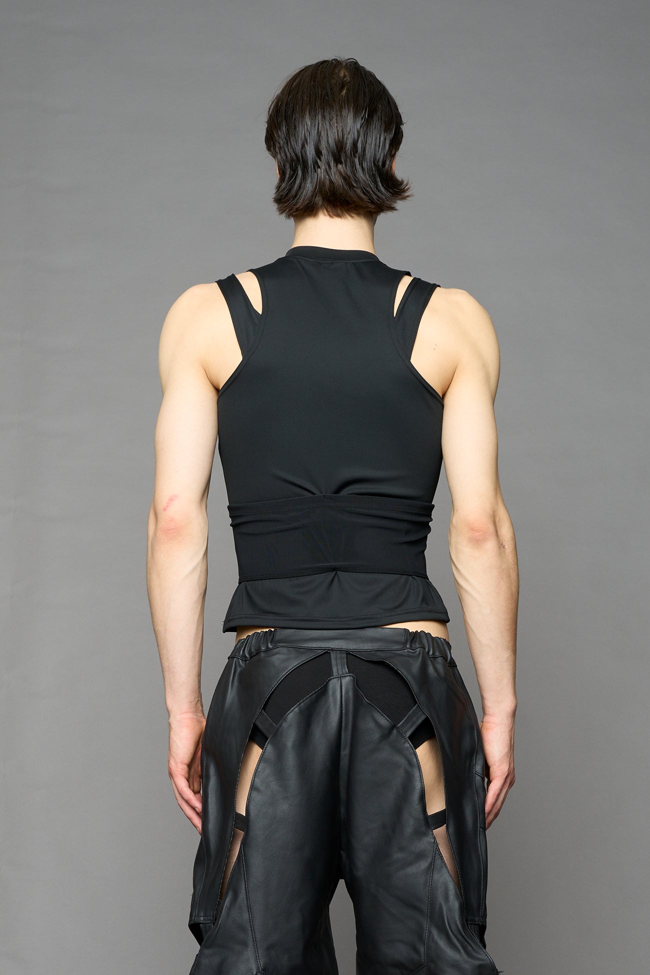 Black contour top by NAMILIA featuring a sculpted fit, corset-style waist with hook-and-eye closure, and high neckline. Statement shaping top.