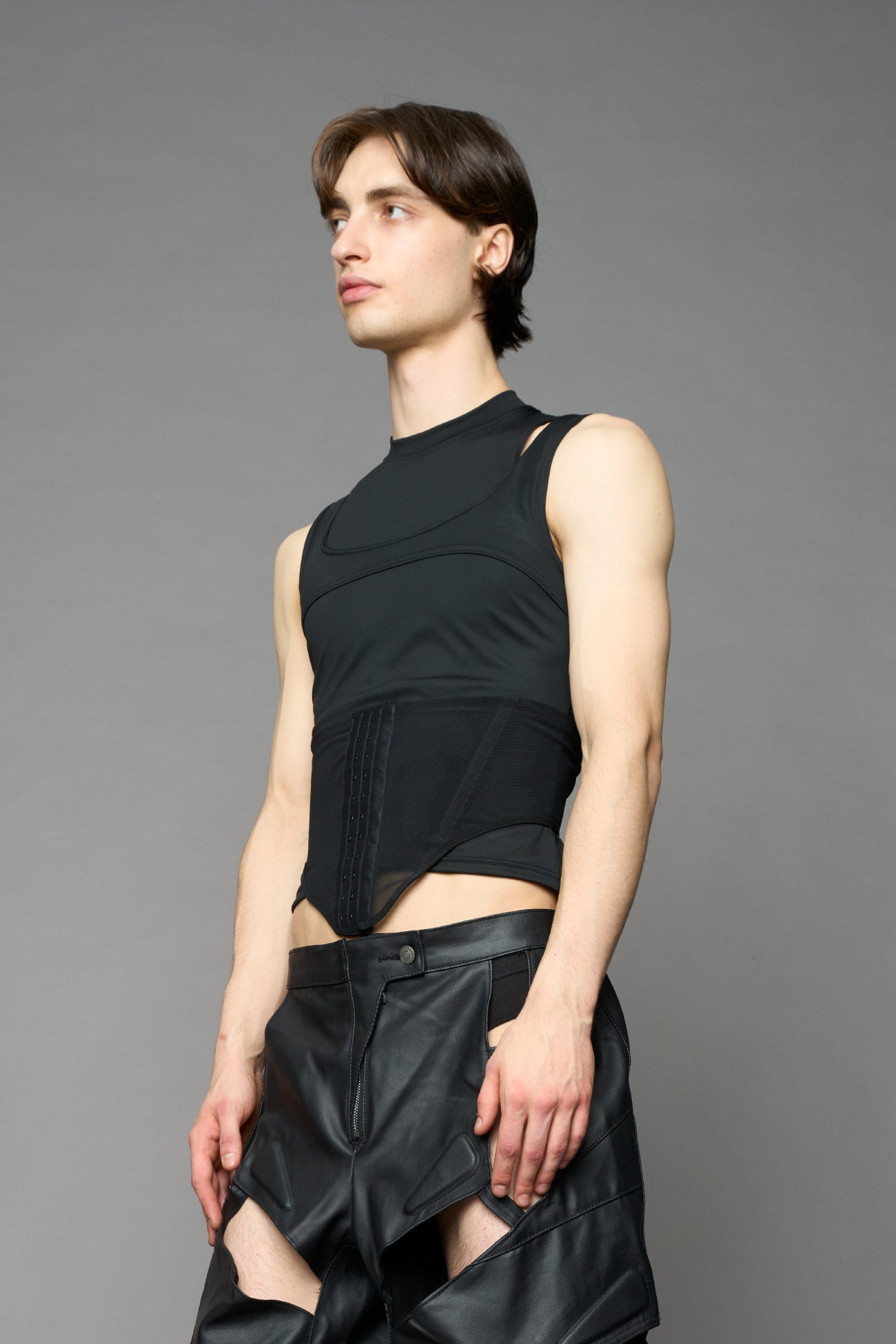 Black contour top by NAMILIA featuring a sculpted fit, corset-style waist with hook-and-eye closure, and high neckline. Statement shaping top.