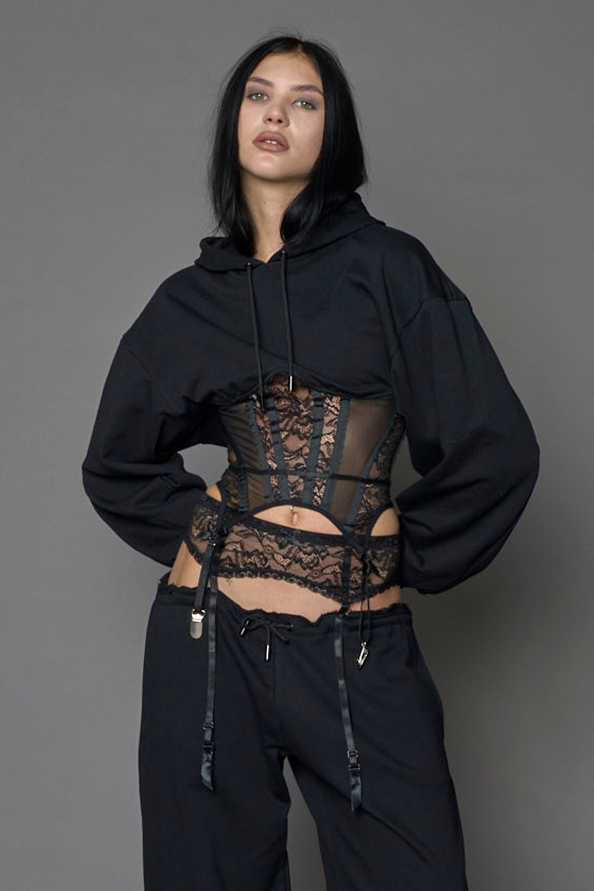 model wearing a lingerie-inspired black hoodie with a lace corset 