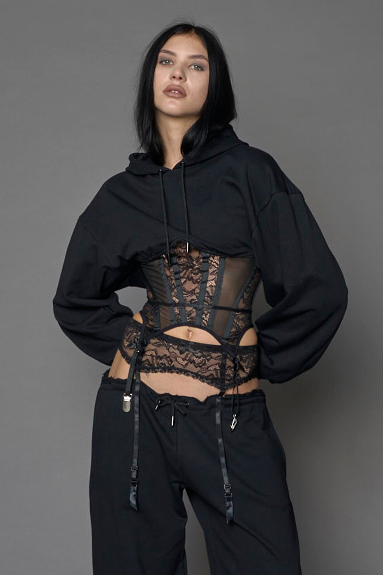 model wearing a lingerie-inspired black hoodie with a lace corset 
