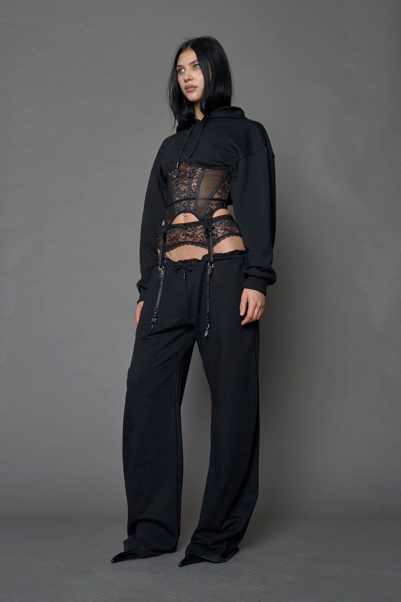 model wearing a lingerie-inspired black hoodie with a lace corset 