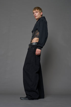 male model wearing a lingerie-inspired black hoodie with a lace corset