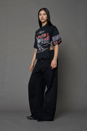 female model wearing a black oversized T-Shirt with a goth-inspired print and a back corset detail