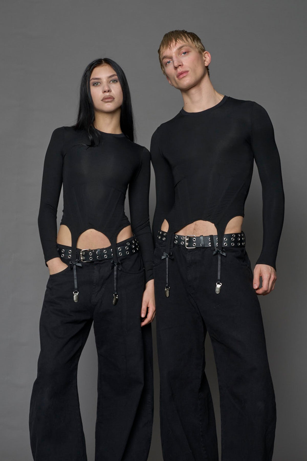 Female and male model wearing a form fitted lingerie-inspired black longsleeve with garter belt detail