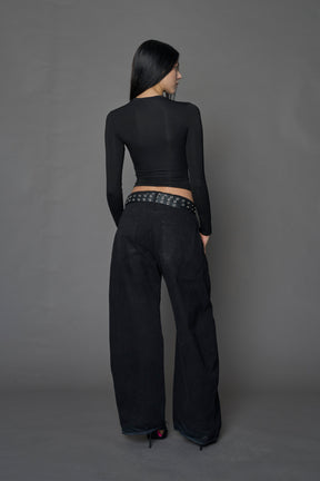 Female model wearing a form fitted lingerie-inspired black longsleeve with garter belt detail