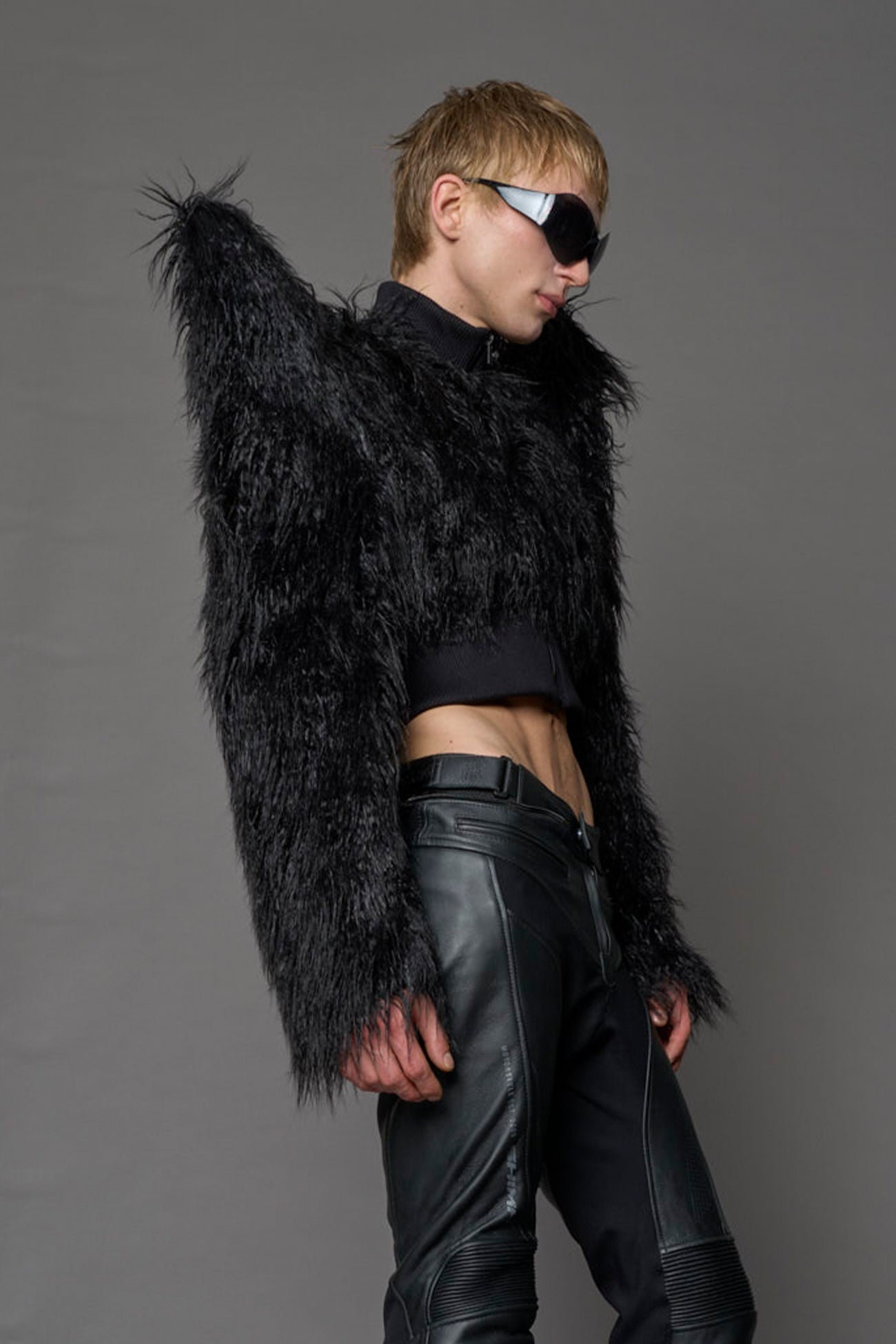 Model wearing black spike shoulder crop faux fur coat