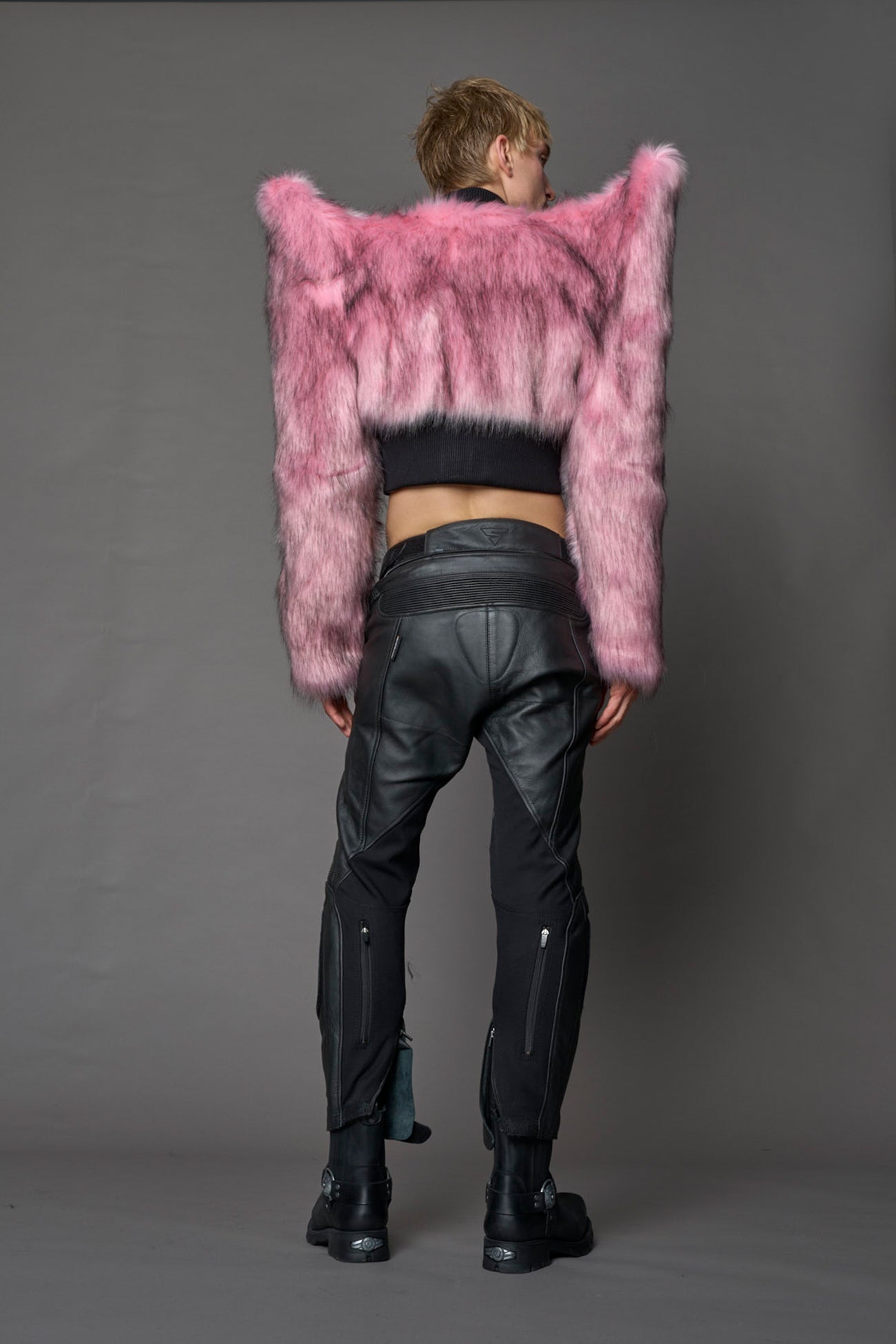 Model wearing pink spike shoulder crop faux fur coat