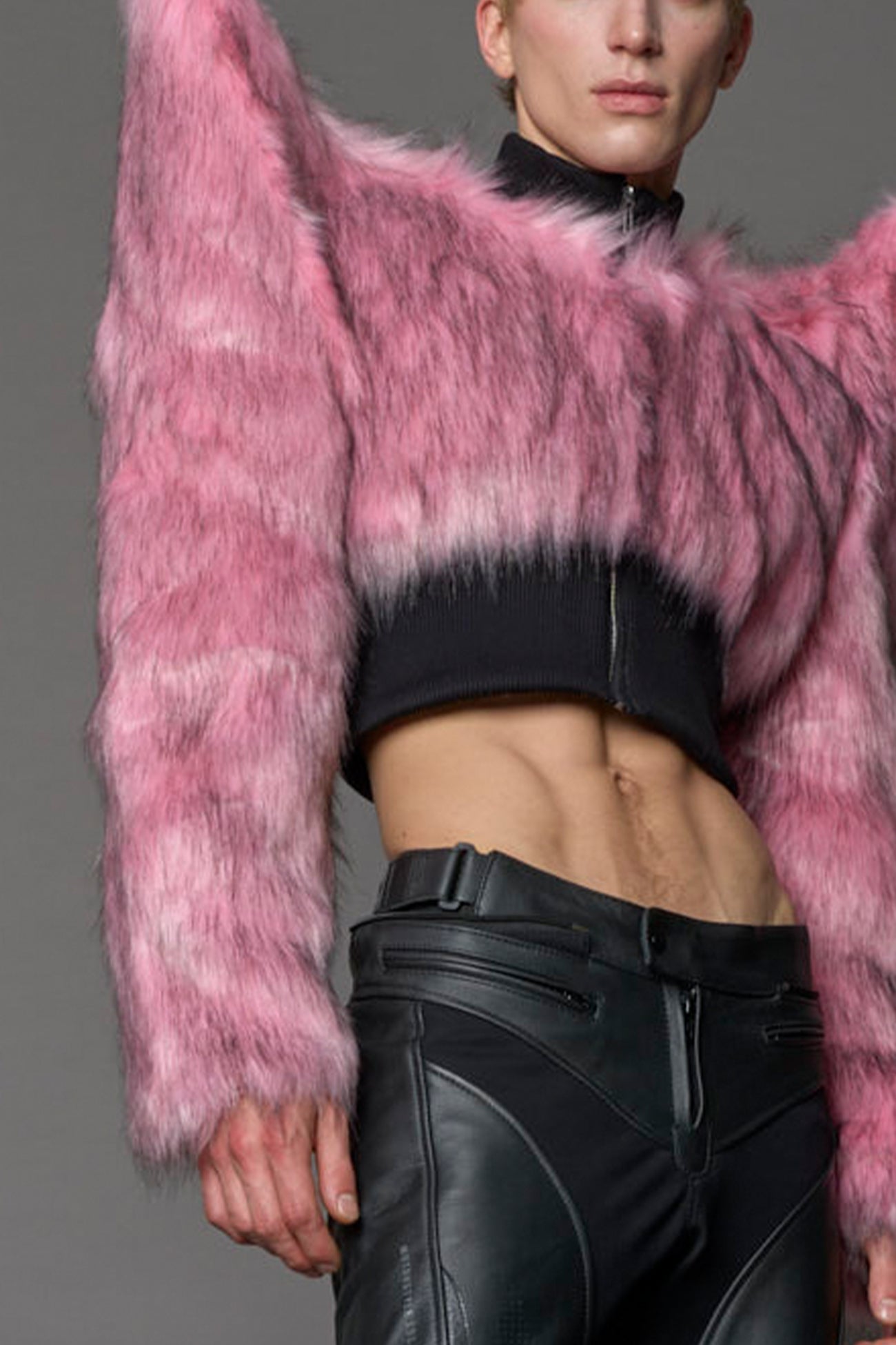 Model wearing pink spike shoulder crop faux fur coat