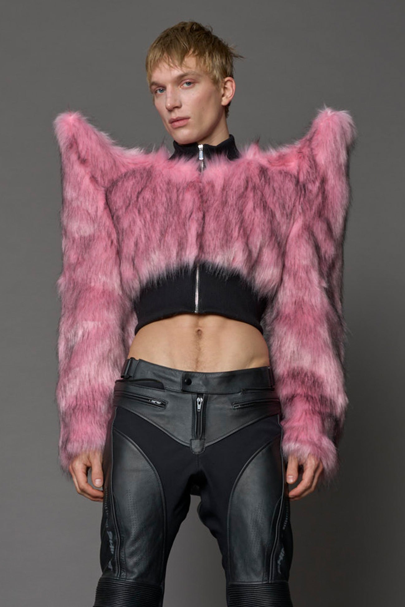 Model wearing pink spike shoulder crop faux fur coat