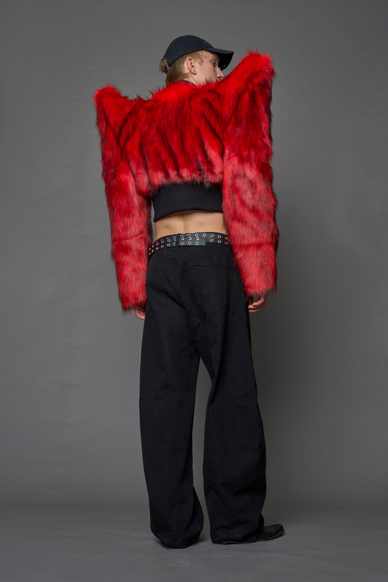 Model wearing red spike shoulder crop faux fur coat
