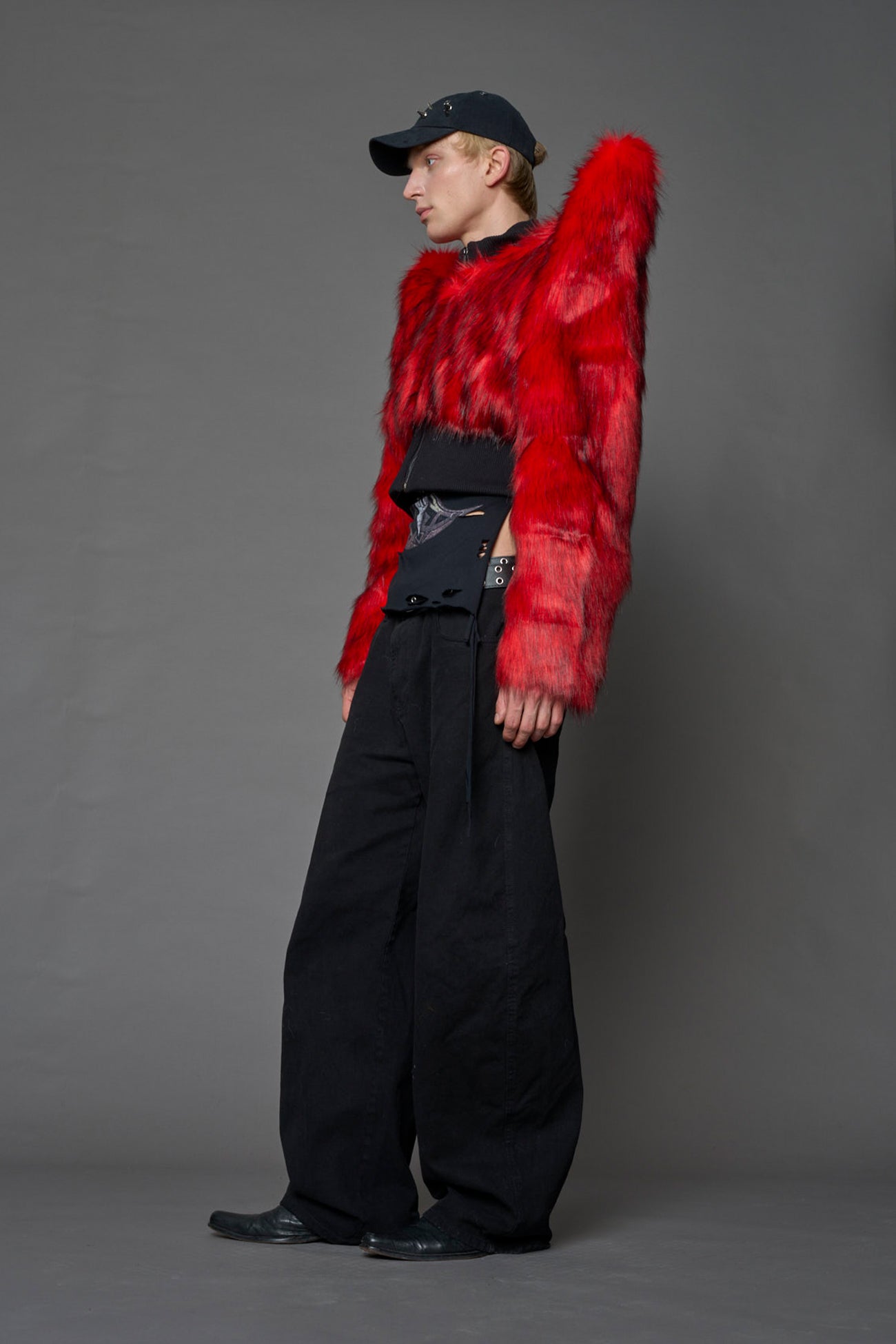 Model wearing red spike shoulder crop faux fur coat