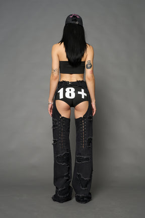Namilia shredded black denim chaps with low-rise fit, extreme thigh cut-outs and distressed straight legs