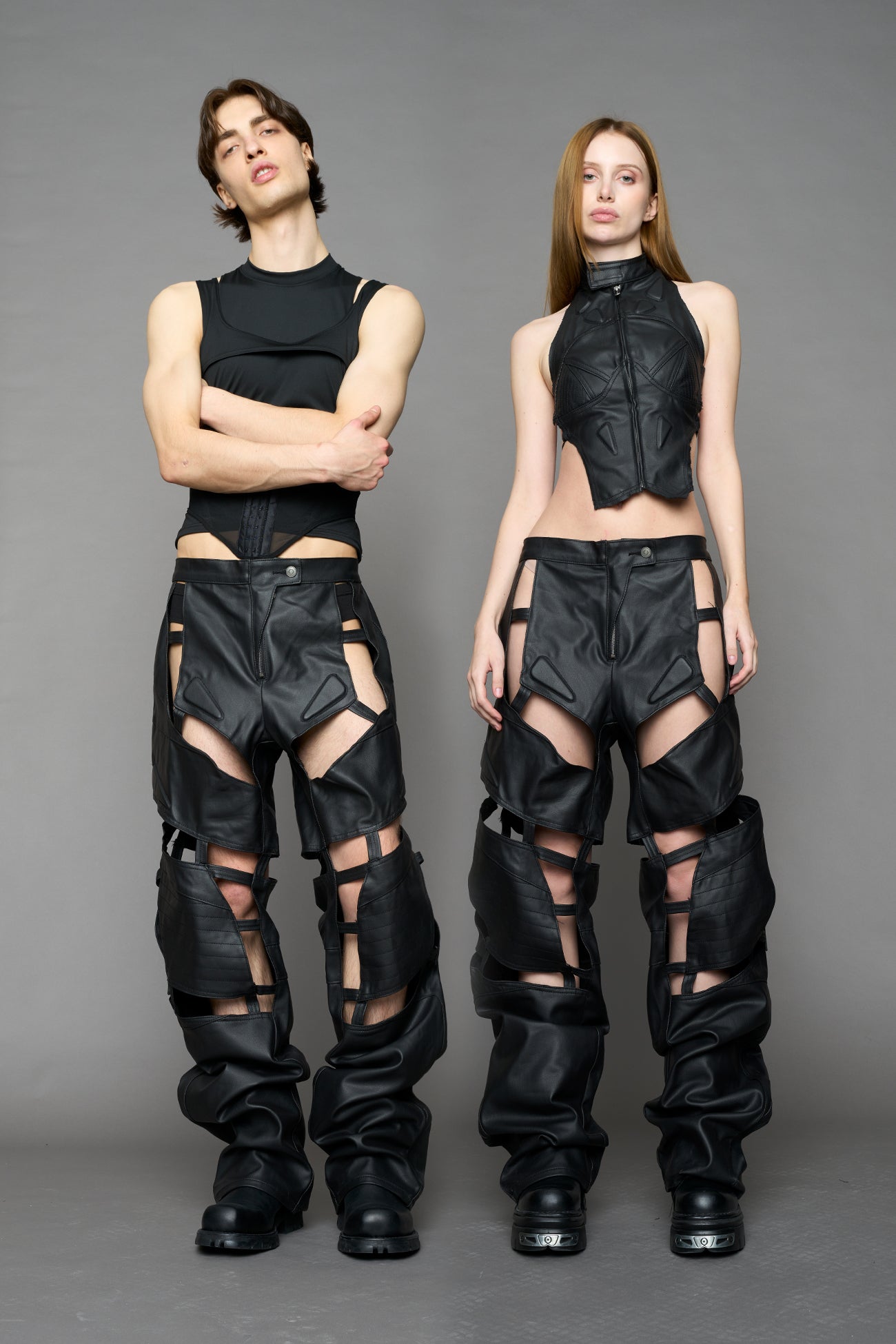 model wearing black coated denim pants with motocross inspired cut outs