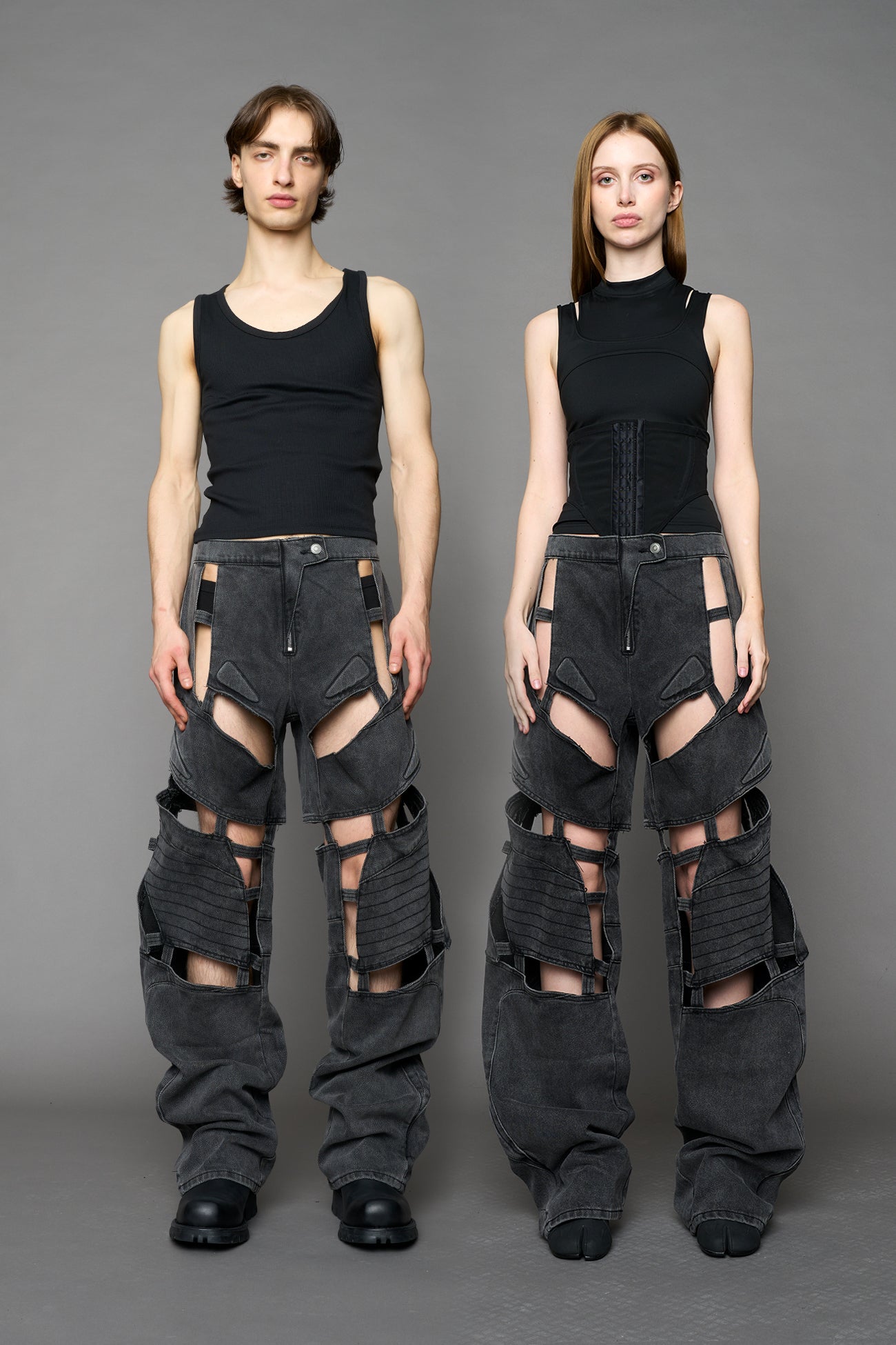 model wearing black washed denim pants with motocross inspired cut outs