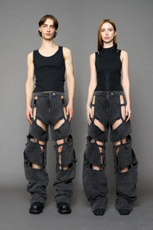 model wearing black washed denim pants with motocross inspired cut outs