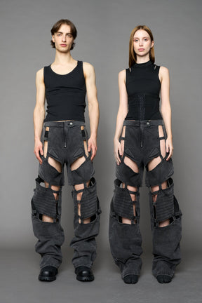 model wearing black washed denim pants with motocross inspired cut outs