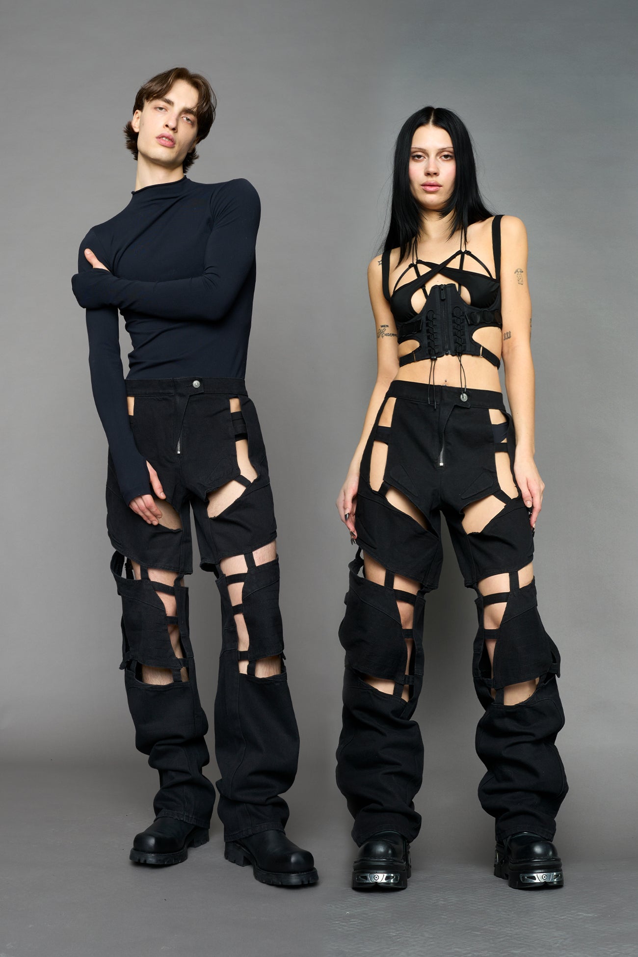 model wearing dark black wash denim pants with motocross inspired cut outs