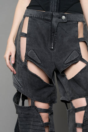 model wearing black washed denim pants with motocross inspired cut outs