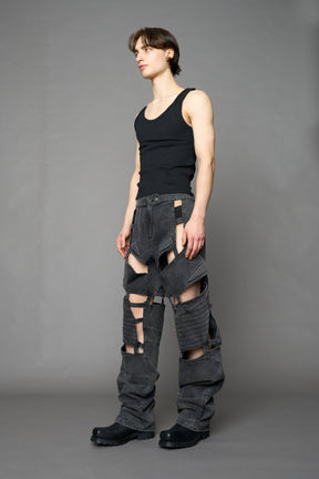 model wearing black washed denim pants with motocross inspired cut outs