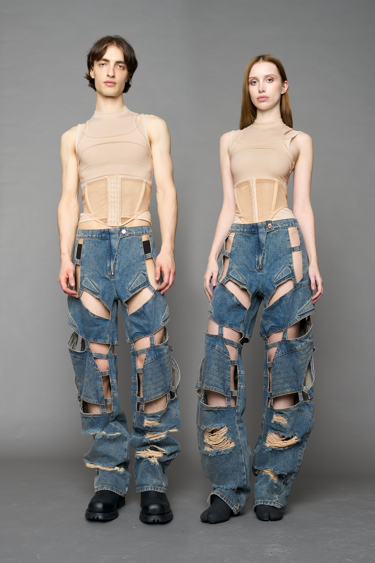 model wearing blue mud denim pants with motocross inspired cut outs