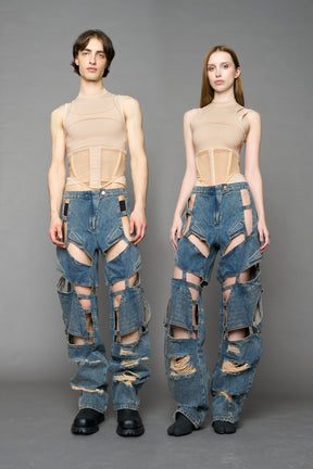 model wearing blue mud denim pants with motocross inspired cut outs