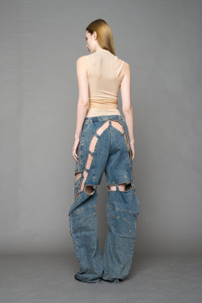 model wearing blue mud denim pants with motocross inspired cut outs