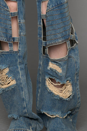 model wearing blue mud denim pants with motocross inspired cut outs