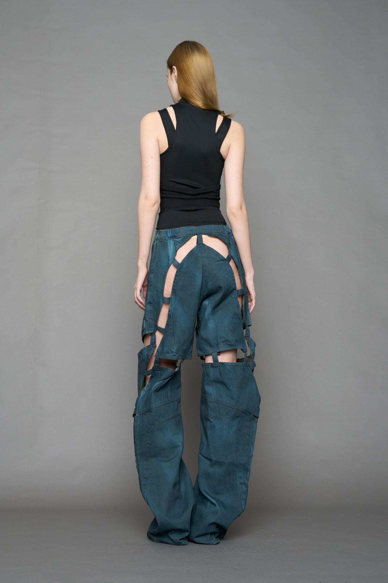 model wearing blue smoke denim pants with motocross inspired cut outs