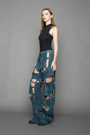 model wearing blue smoke denim pants with motocross inspired cut outs
