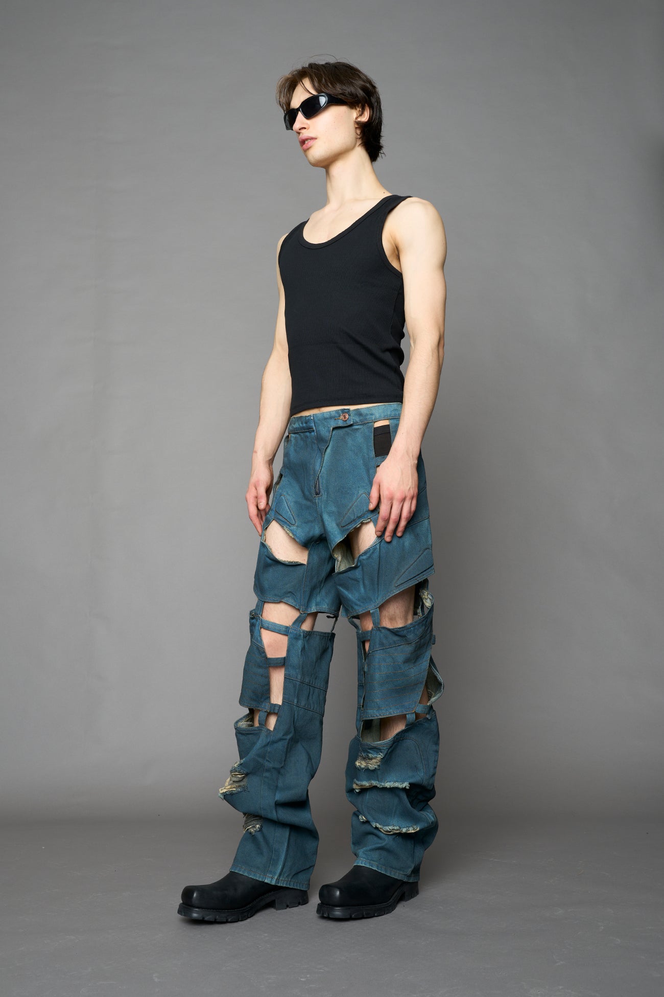 model wearing blue smoke denim pants with motocross inspired cut outs
