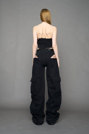 model wearing black dark washed denim trousers with cut out design and 3D pockets