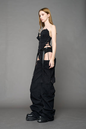 model wearing black dark washed denim trousers with cut out design and 3D pockets