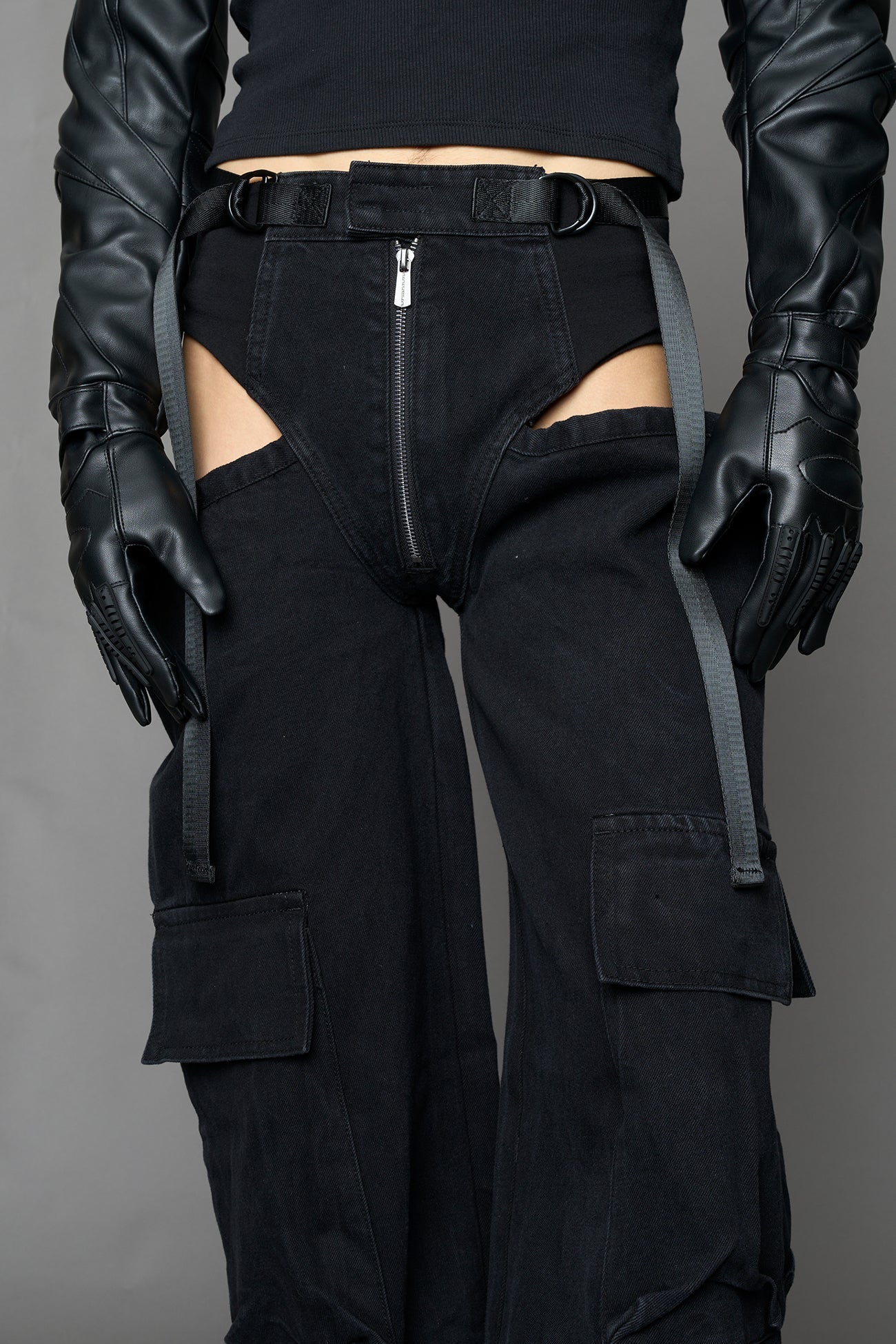 model wearing black dark washed denim trousers with cut out design and 3D pockets